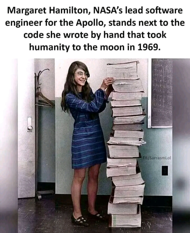 Margaret Hamilton standing next to her computer code that took man to the moon in 1969